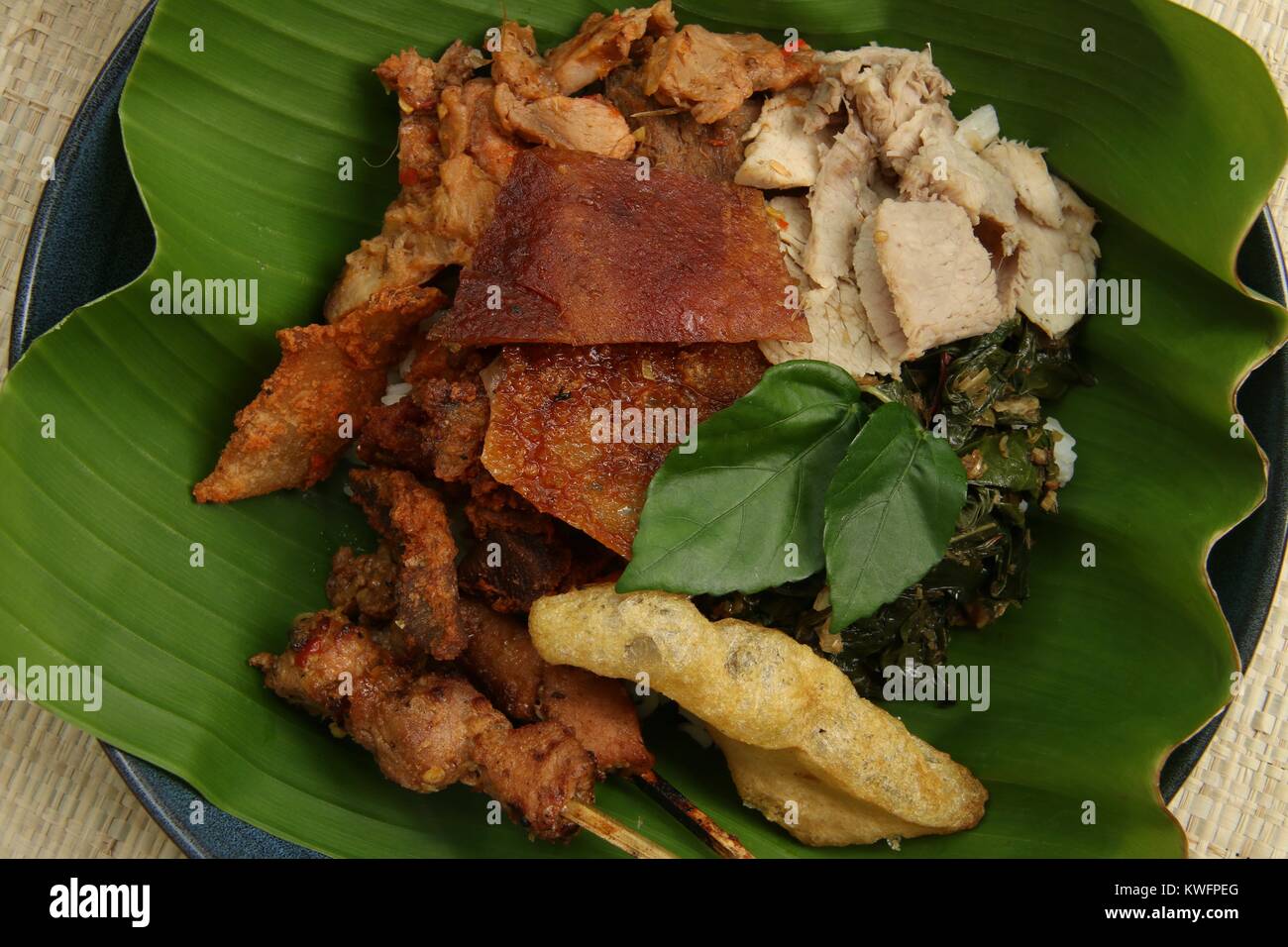 Nasi Campur babi guling. Balinesen Reis Reisgericht mit gedämpftem Reis garniert mit verschiedenen Gerichte der traditionellen Schweinebraten. Stockfoto