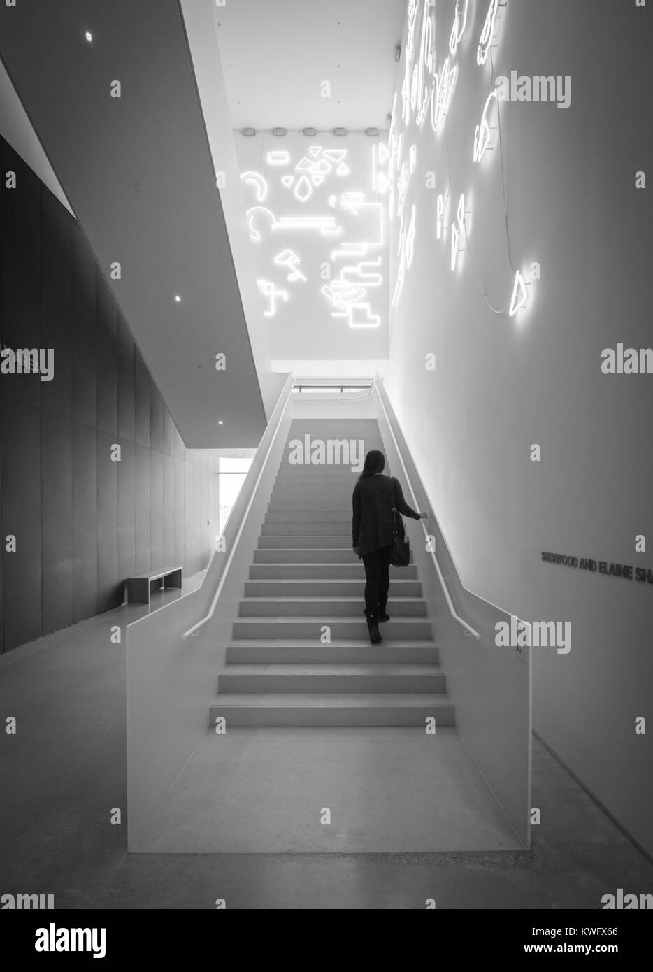Eine junge Frau geht die Treppen hoch mit einem Neon Licht Installation namens Lucky Charms von der Künstlerin Pae White an der n Galerie für Moderne Kunst. Saskatoon. Stockfoto