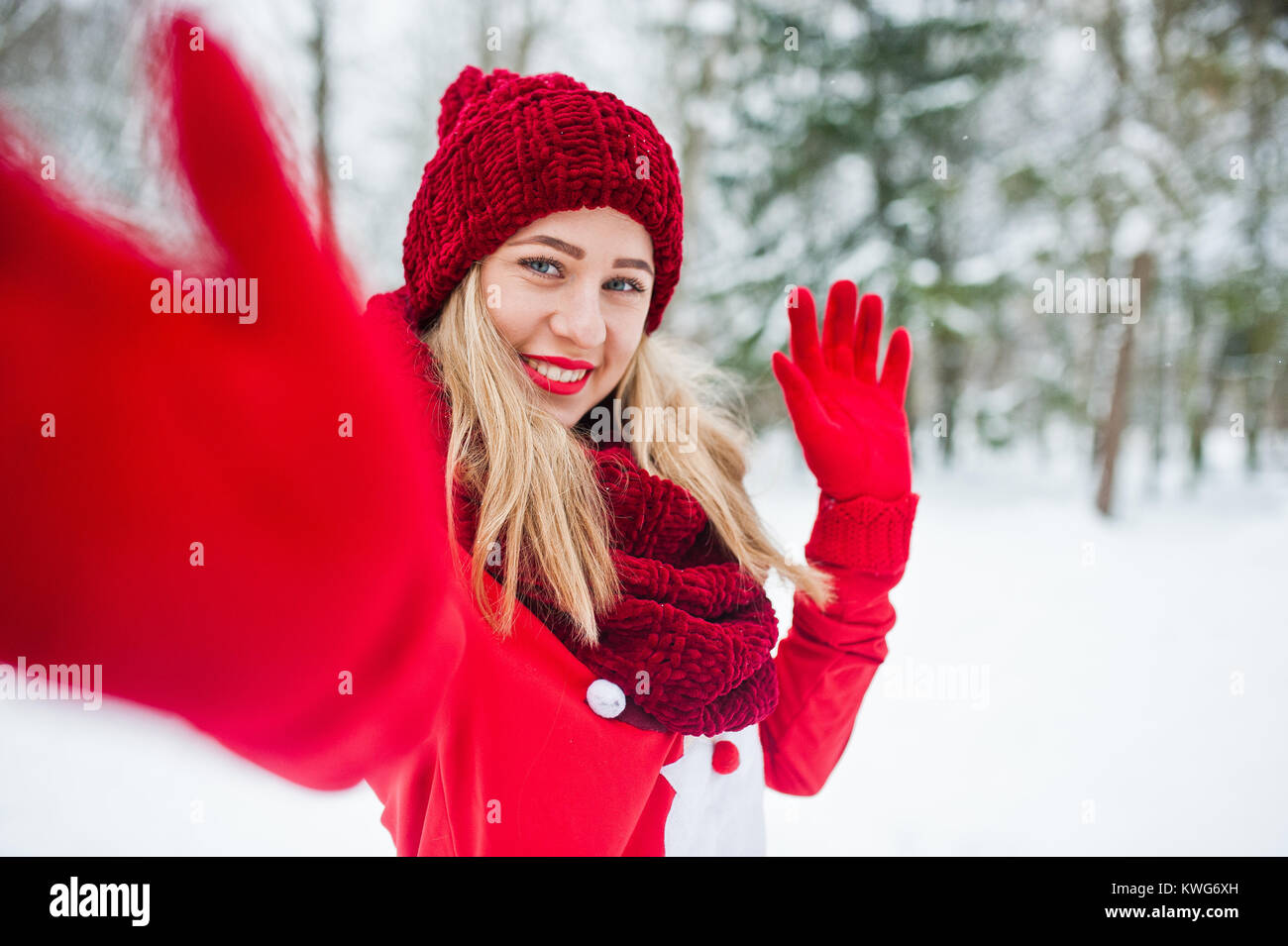 Blonde Mädchen in roten Schal, Mütze und weihnachtsmänner Pullover posiert im Park im Winter Tag. Stockfoto