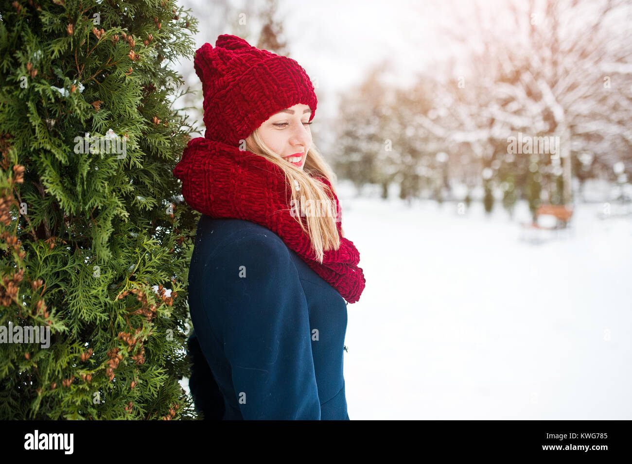 Blonde Mädchen in roten Schal und Mantel Wandern im Park im Winter Tag. Stockfoto