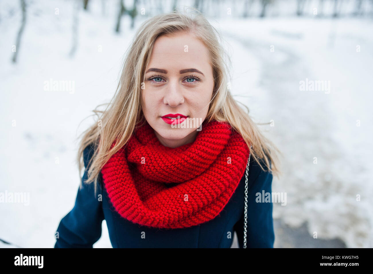 Portrai des blonden Mädchen in roten Schal und Mantel auf Wintertag. Stockfoto