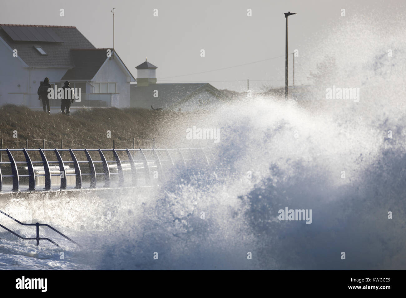 Anglesey, Wales 2018. UK Wetter. Eine schwere Met Office Warnung hat für das fünfte Sturm der britischen Saison ausgestellt wurde Tropensturm Eleanor. Mit einem Anstieg der Gefahr durch die aktuelle Mond- und Gezeiten Hochwasserwarnungen für viele Bereiche zusammen mit gales Winde wahrscheinlich Schaden zu verursachen. Wellen und Wind Crash in Trearddur Bay auf Anglesey im Norden von Wales als ein paar Mutige die sich brechenden Wellen und Gischt an der Küste Stockfoto