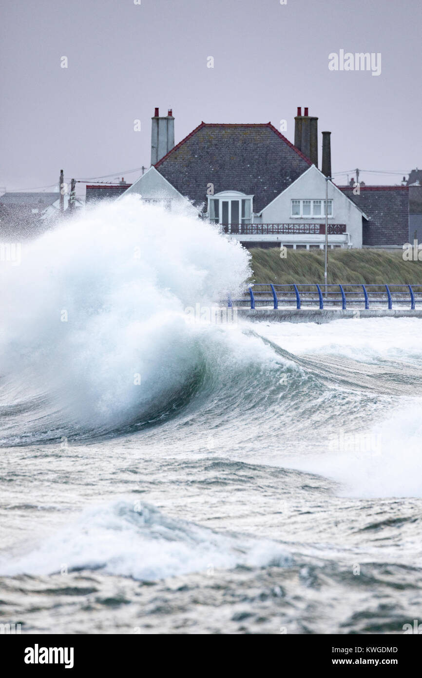Eine riesige Welle als Folge des Sturms Eleanor Pässe vor einem Haus in der Nähe der Küste und der Gefahr von Hochwasser an Treaddur Bay, Anglesey, Wales als Welle nach Welle zerschlägt die Küste Stockfoto
