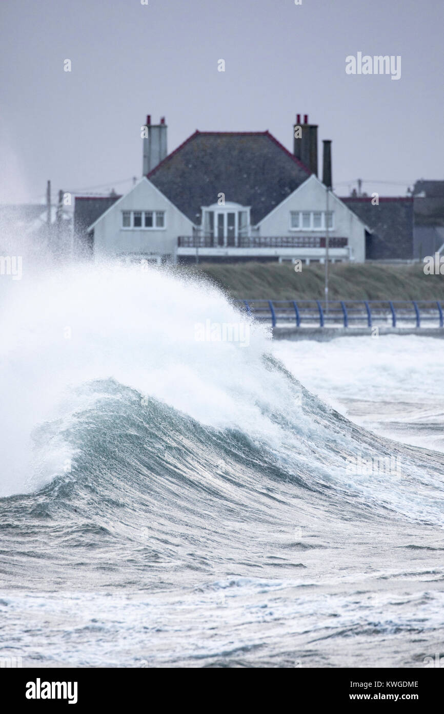 Eine riesige Welle als Folge des Sturms Eleanor Pässe vor einem Haus in der Nähe der Küste und der Gefahr von Hochwasser an Treaddur Bay, Anglesey, Wales als Welle nach Welle zerschlägt die Küste Stockfoto