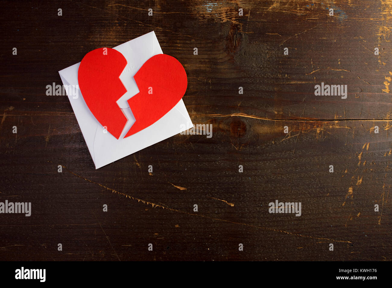 Eine Pause bis zum Valentinstag Umschlag Brief mit einem gebrochenen zerrissenes Papier Herzen ontop auf Holz Hintergrund Textur. Stockfoto