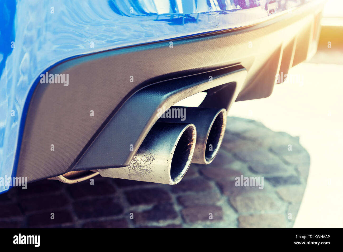 Nahaufnahme von einem Auto doppelte Auspuffrohr im Sonnenlicht Hintergrund Stockfoto