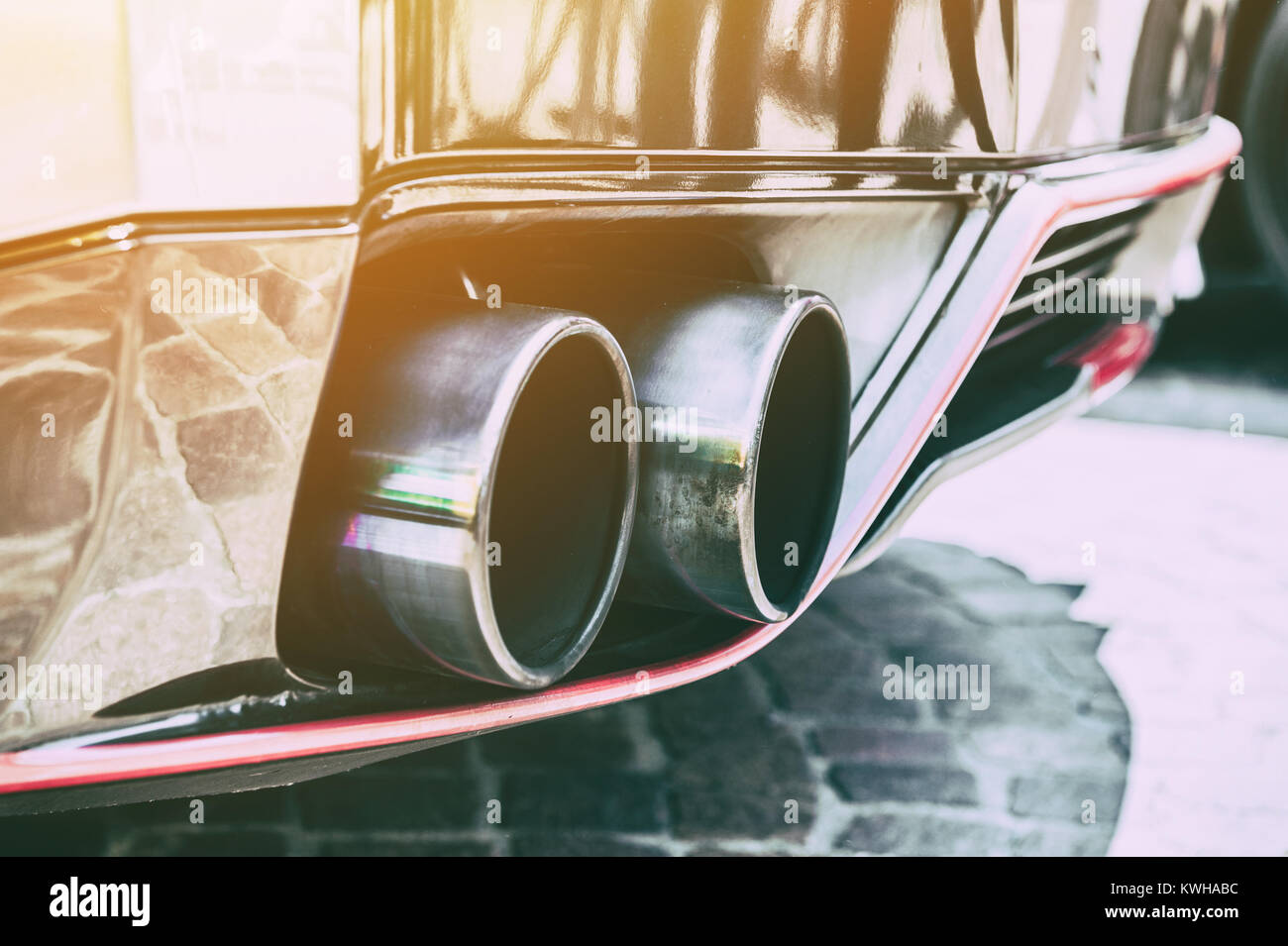 Nahaufnahme von einem Auto doppelte Auspuffrohr im Sonnenlicht Hintergrund Stockfoto
