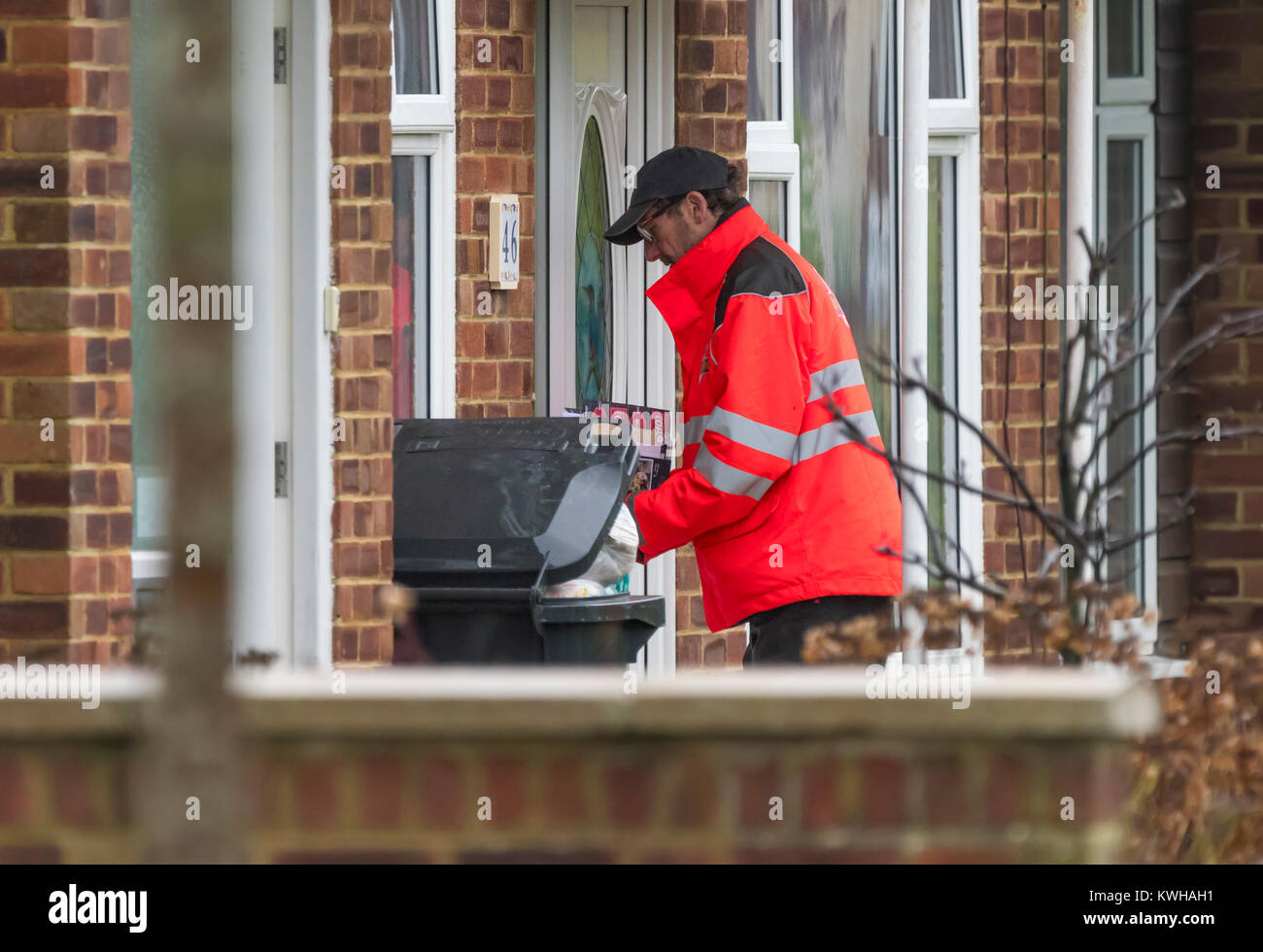 Royal Mail Briefträger die Post durch einen Buchstaben, um ein Haus in England, Großbritannien. Stockfoto