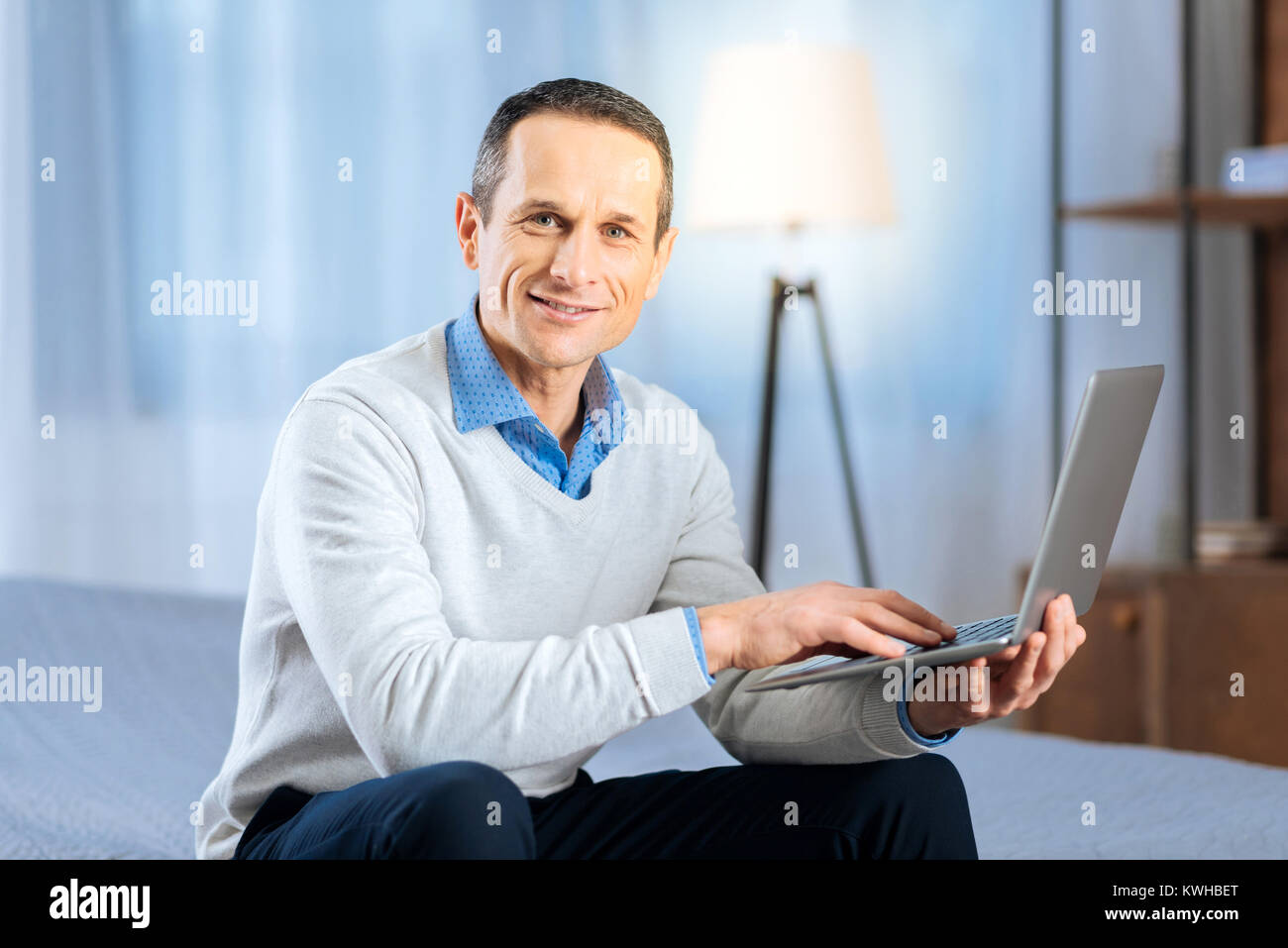 Gut aussehender Mann mittleren Alters mit seinem Laptop posing Stockfoto