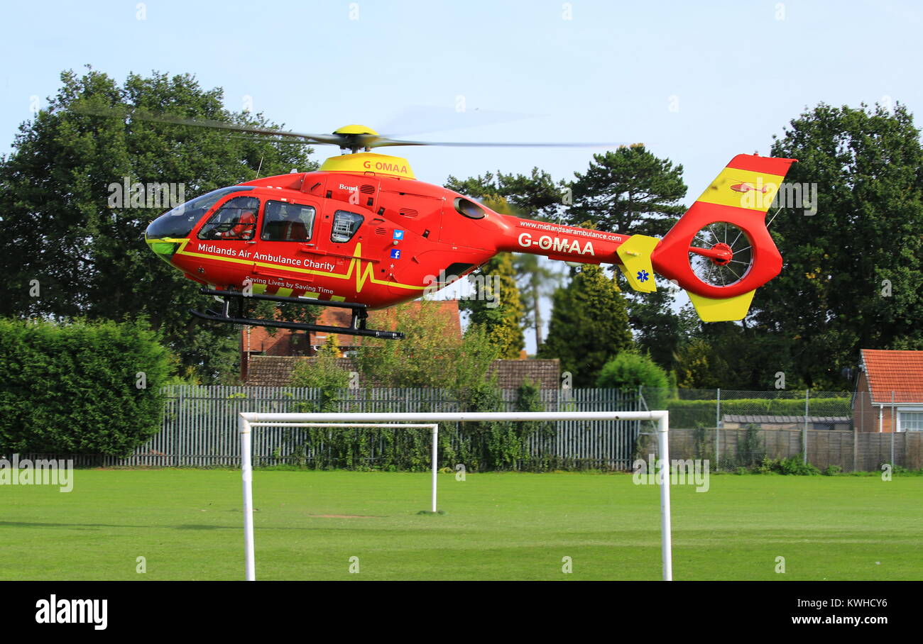 Midlands Air Ambulance anreisen, auf dem Dorfplatz in Fernhill Heide Worcestershire auf einen Notfall zu besuchen. Stockfoto