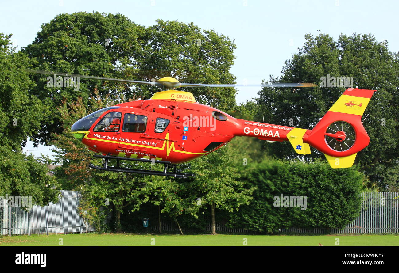 Midlands Air Ambulance anreisen, auf dem Dorfplatz in Fernhill Heide Worcestershire auf einen Notfall zu besuchen. Stockfoto