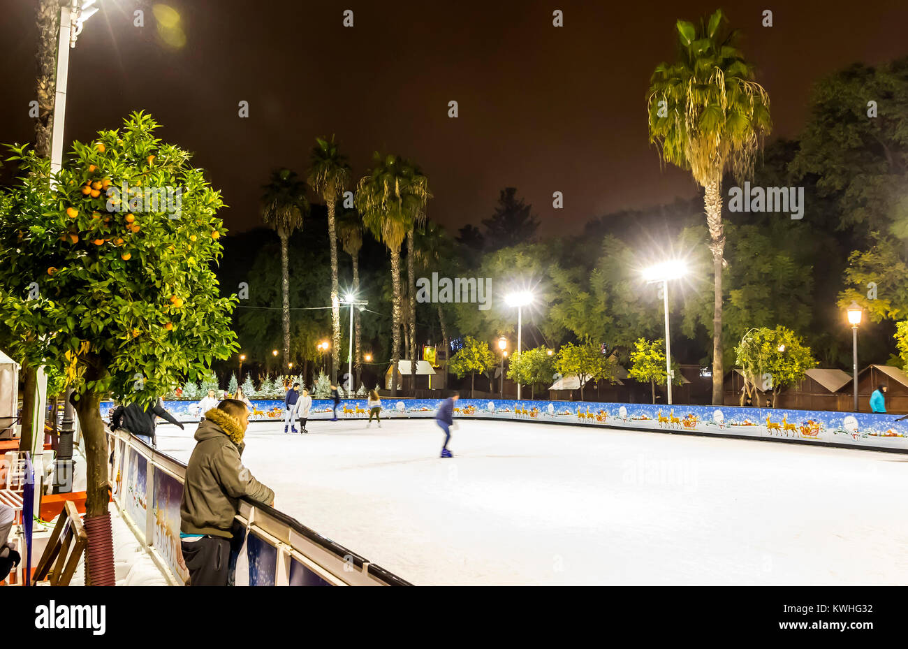 Schlittschuhläufer Spaß auf der Eislaufbahn am traditionellen Weihnachtsmarkt am Prado de San Sebastian im Zentrum von Sevilla, Spanien Stockfoto