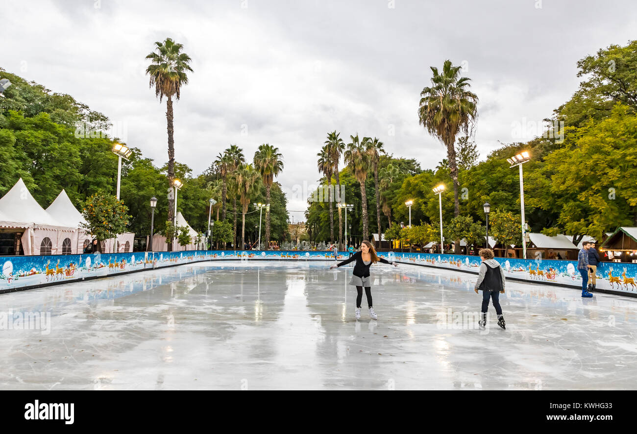 Schlittschuhläufer Spaß auf der Eislaufbahn am traditionellen Weihnachtsmarkt am Prado de San Sebastian im Zentrum von Sevilla, Spanien Stockfoto