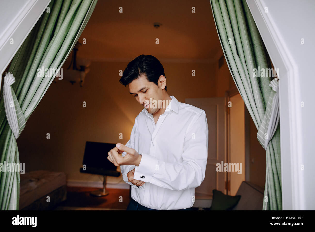 Bräutigam trägt Manschettenknöpfe und Hemd Stockfoto
