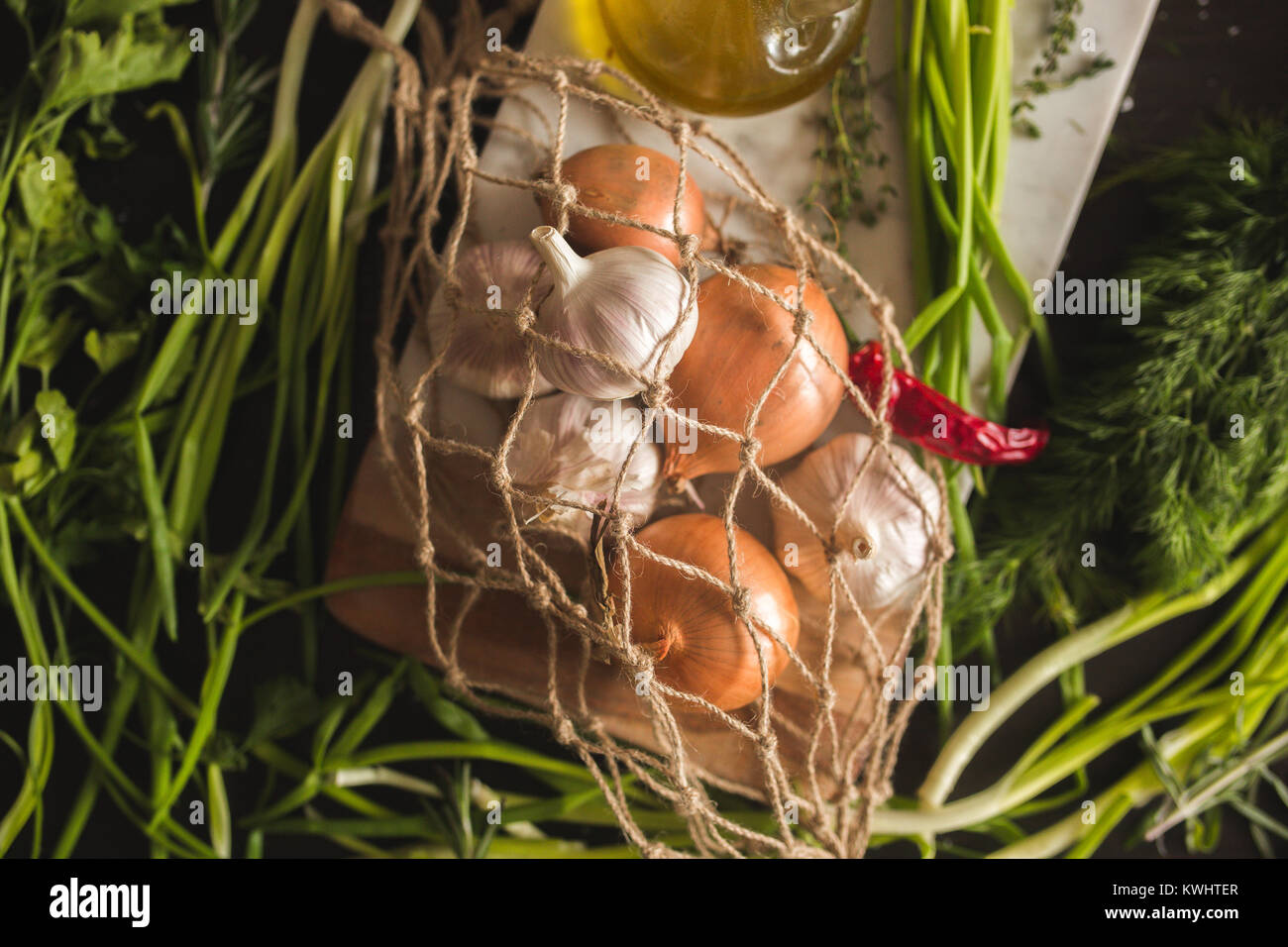 Rohen Knoblauch, Zwiebel, Dill und Petersilie für Suppe zum Abendessen auf dem hölzernen Tisch Hintergrund. Rustikales essen Styling. Natürliche Zutaten für gesundes Rezept. C Stockfoto