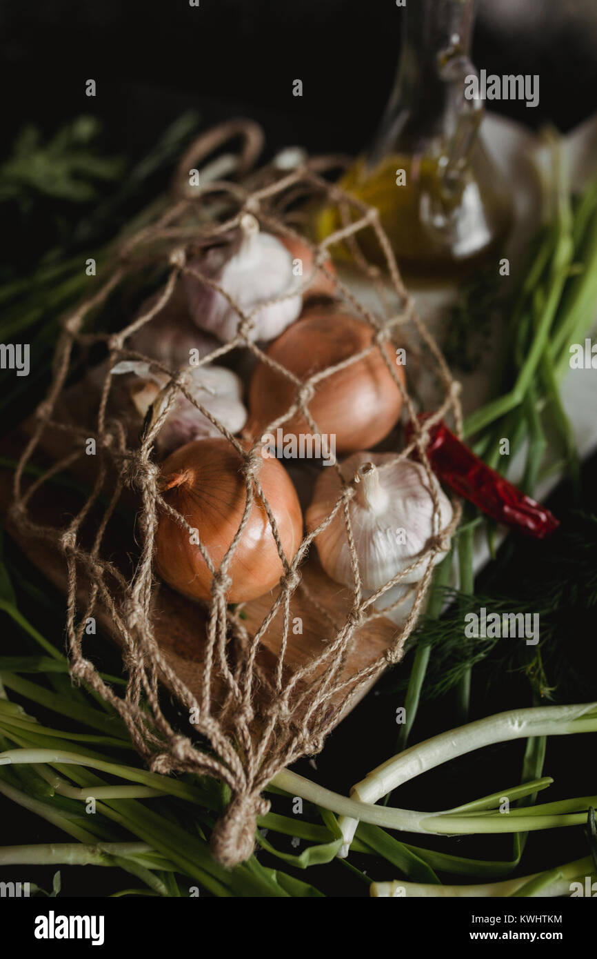 Rohen Knoblauch, Zwiebel, Dill und Petersilie für Suppe zum Abendessen auf dem hölzernen Tisch Hintergrund. Rustikales essen Styling. Natürliche Zutaten für gesundes Rezept. C Stockfoto