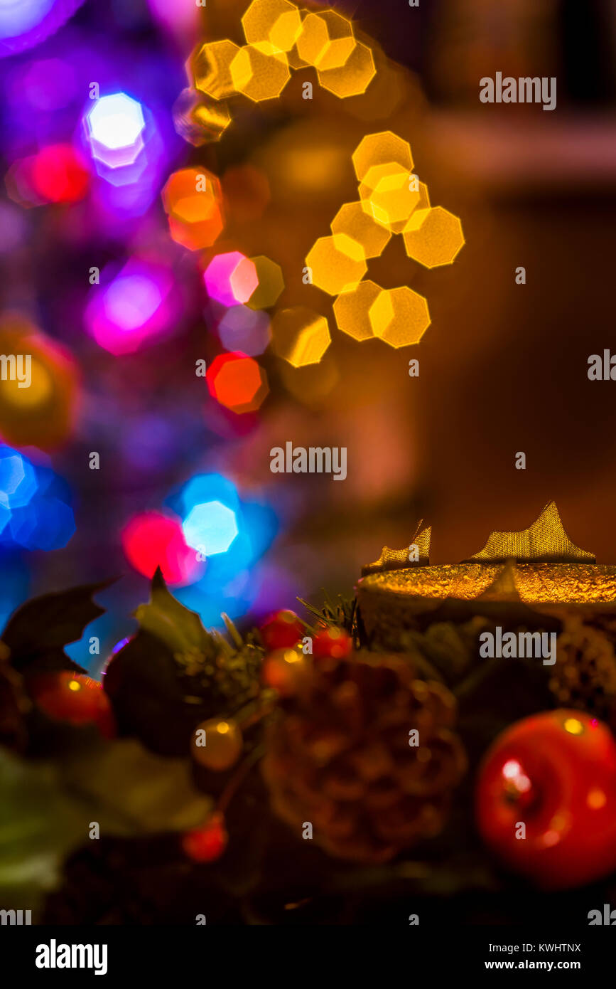 Weihnachtsgirlande mit Kerze und Baum Lichter im Hintergrund, festliche warmen Ambiente. Stockfoto