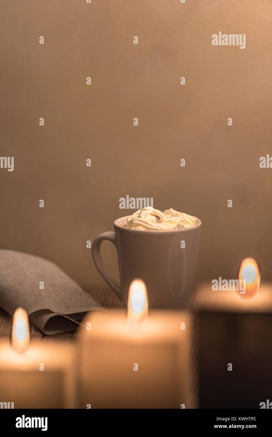 Warmes gemütliches Abendessen bei Kerzenschein Tisch mit einer Tasse cremige heiße Schokolade. Stockfoto