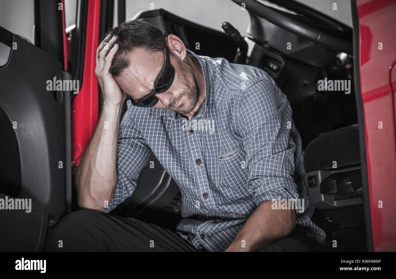 Frustriert kaukasischen Semi Truck Driver in Problem mit seinem Lkw und Job. Stockfoto