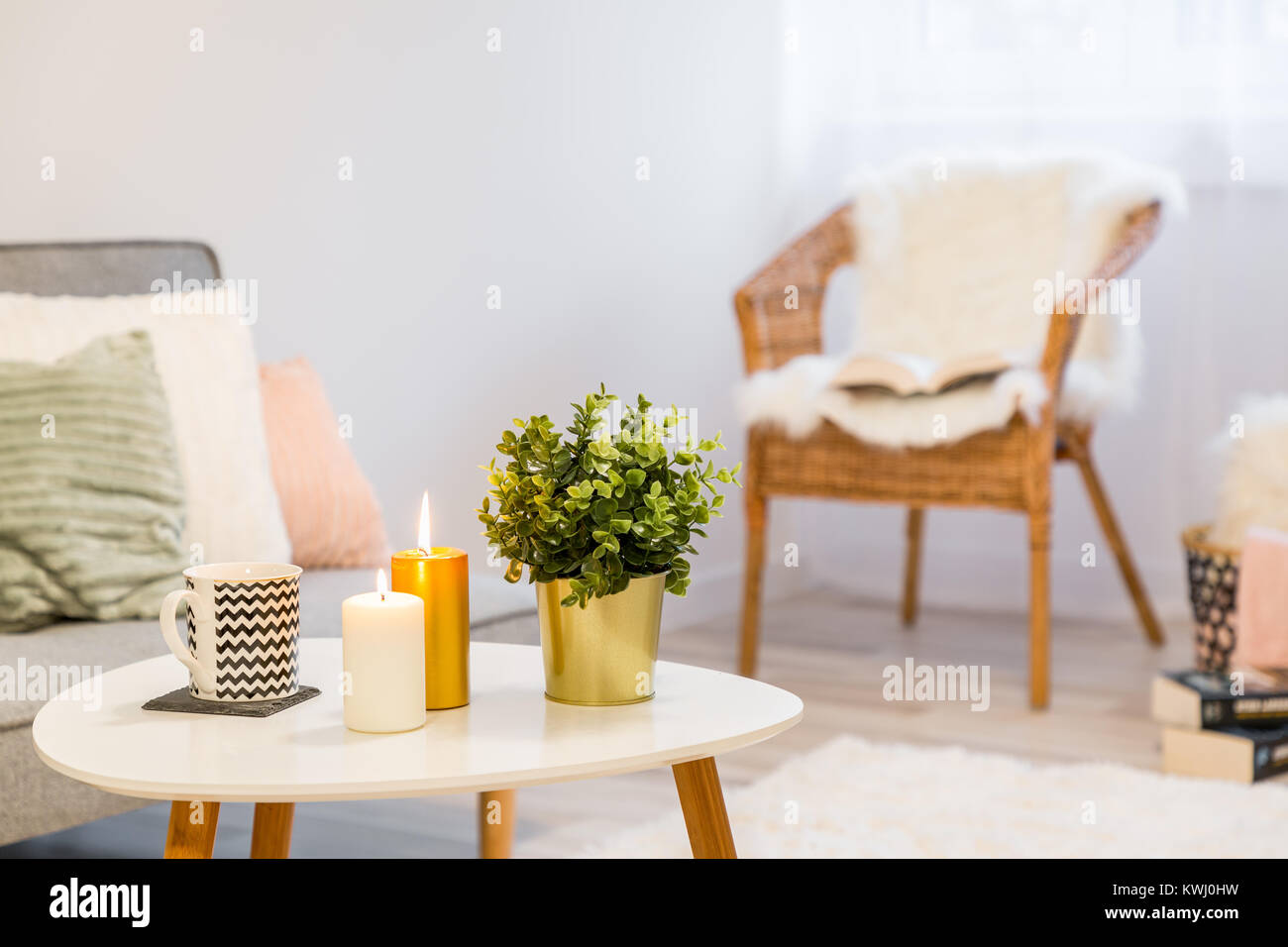 Home Einrichtung mit weißen Couchtisch und Korbstuhl Stockfoto