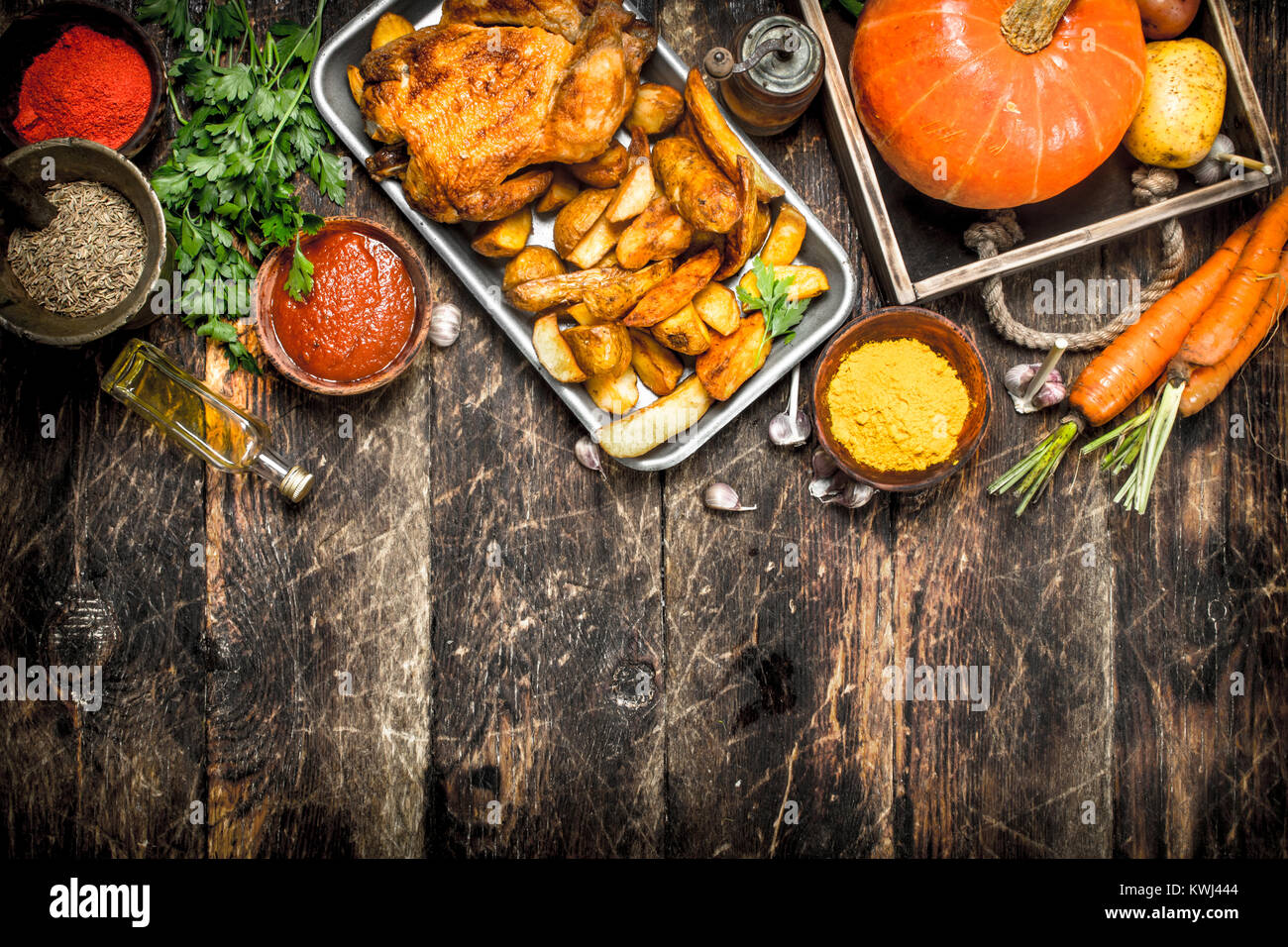 Gebratenes Huhn mit Gemüse und Gewürzen. Auf einer hölzernen Hintergrund. Stockfoto