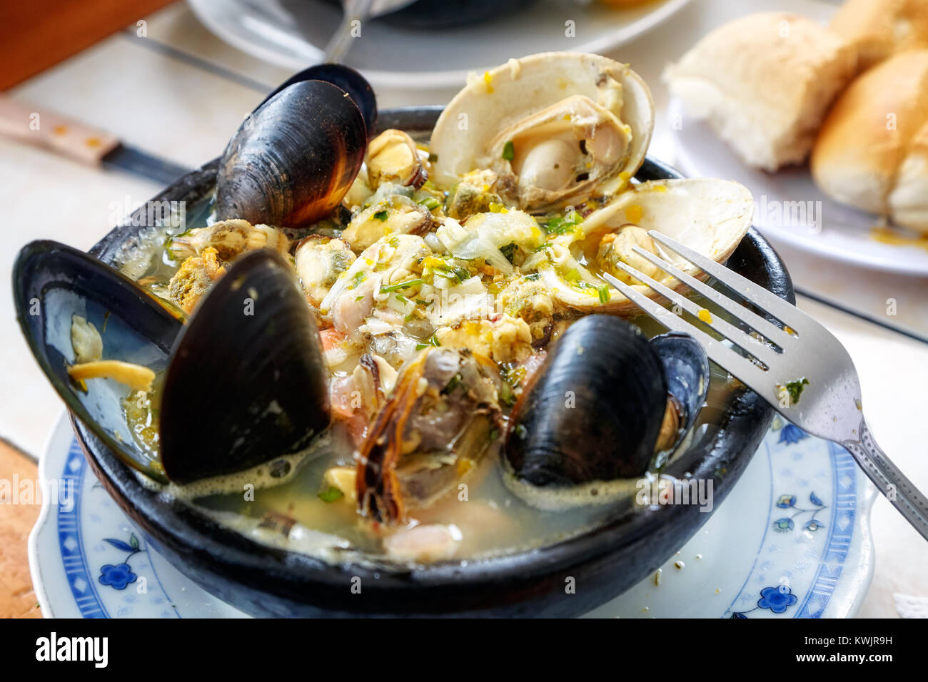 Paila Marina genießen in Santiago de Chile. Es ist eine traditionelle chilenische Seafood Suppe mit Meeresfrüchten, Fisch und eine Vielfalt von Kräutern und Gewürzen. Stockfoto