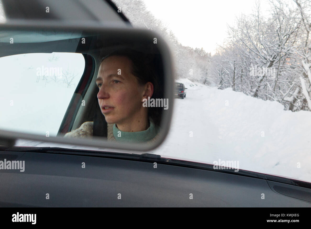 Darlehen einzelne Frau Treiber entlang fahren rutschigen eisigen verschneiten Französischen Alpen Country Road, mit Eis, nach einem Blizzard. Schlechte Bedingungen im Winter. Frankreich Stockfoto