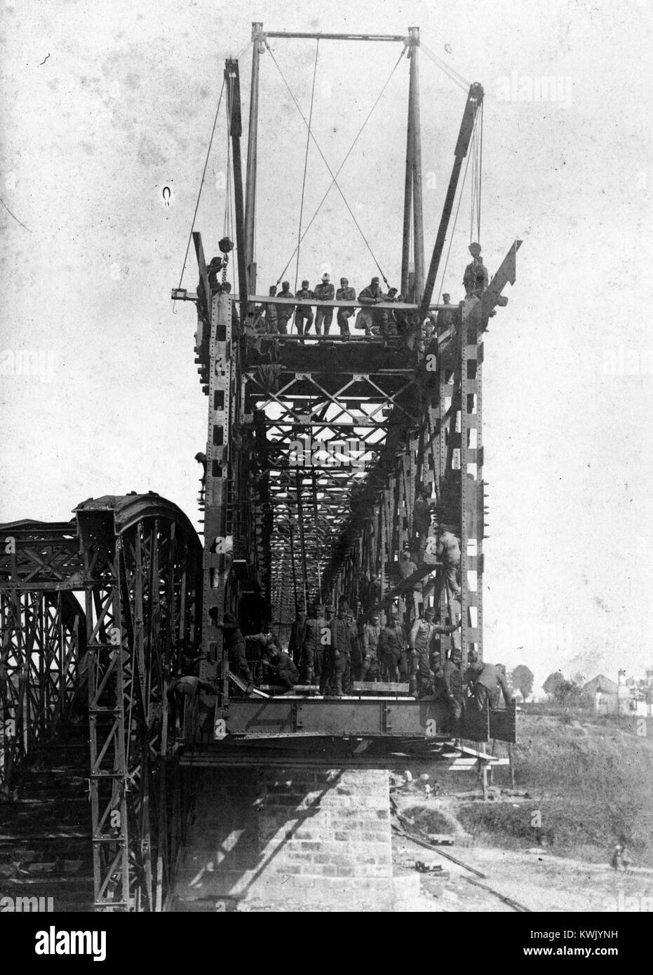 Das Bild zeigt eine urbane Straßenszene mit den Überresten eines abgerissenen Gebäudes, Schutt und Wiederaufbauaktivitäten im Vordergrund, die den architektonischen Wandel und die Stadterneuerung der Nachkriegszeit in einer mitteleuropäischen Stadt veranschaulichen. Stockfoto