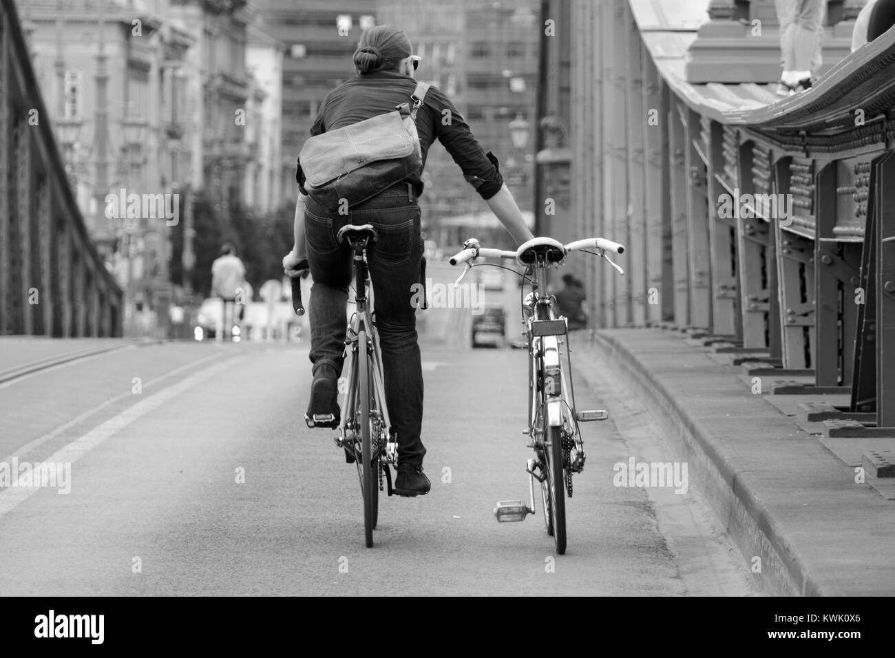 Mann reiten Fahrrad trundles ein anderes Fahrrad entlang Stockfoto