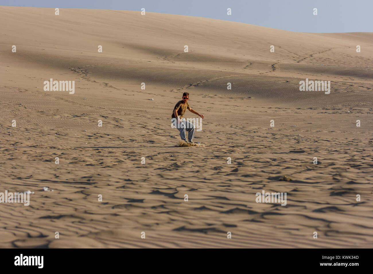 Bild von einem jungen Mann bei Sonnenuntergang, Sandboarding, Ica Huacachina, Peru Stockfoto