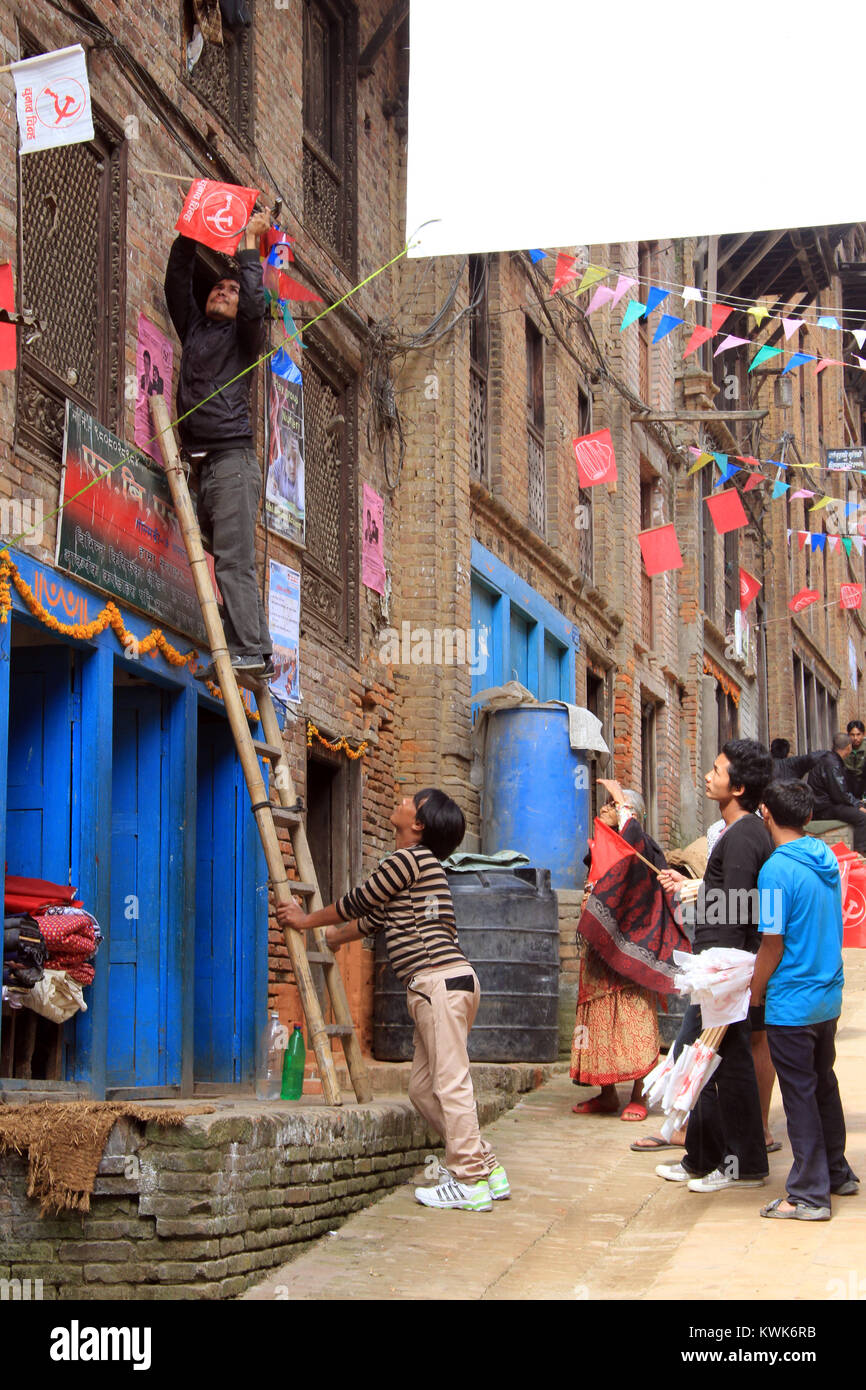 BHAKTAPUR, Nepal - ca. November 2013 Menschen mit Fahnen auf der Straße vor der Wahl Stockfoto