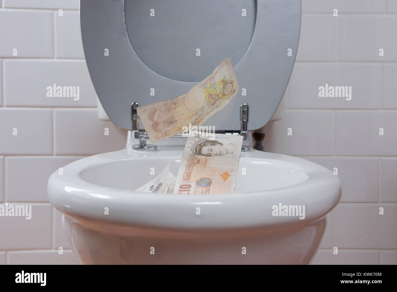 Konzept - Werfen Sie Ihr Geld in die Toilette Stockfoto