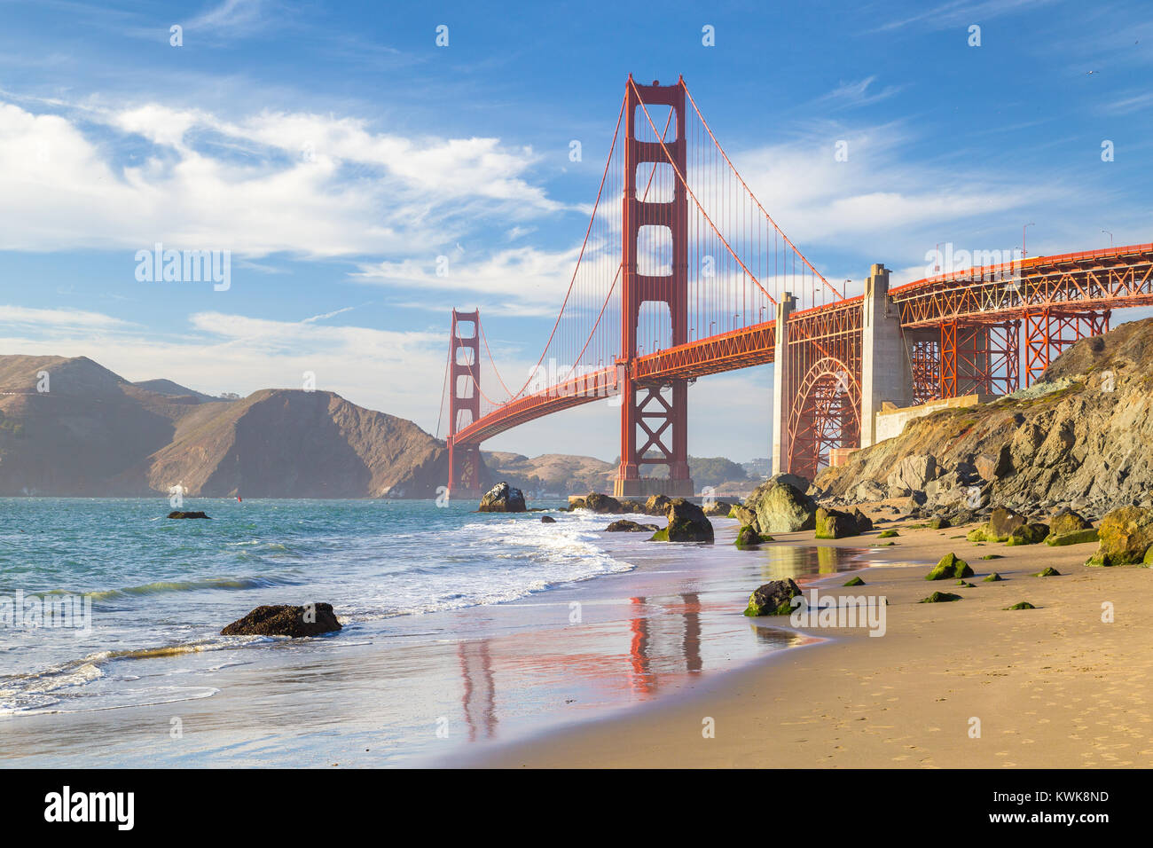 Klassische Panoramablick auf die berühmte Golden Gate Bridge vom malerischen Baker Beach in wunderschönen goldenen Abendlicht gesehen an einem sonnigen Tag mit blauen Himmel und Cl Stockfoto