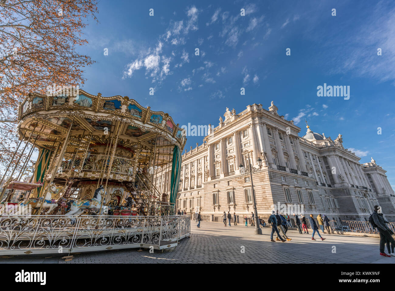 Touristen und Einheimische Menschen zu Fuß und genießen Sie buntes Karussell, rondabaout oder Merry-go-round vor der königlichen Palast in Madrid, Spanien Stockfoto