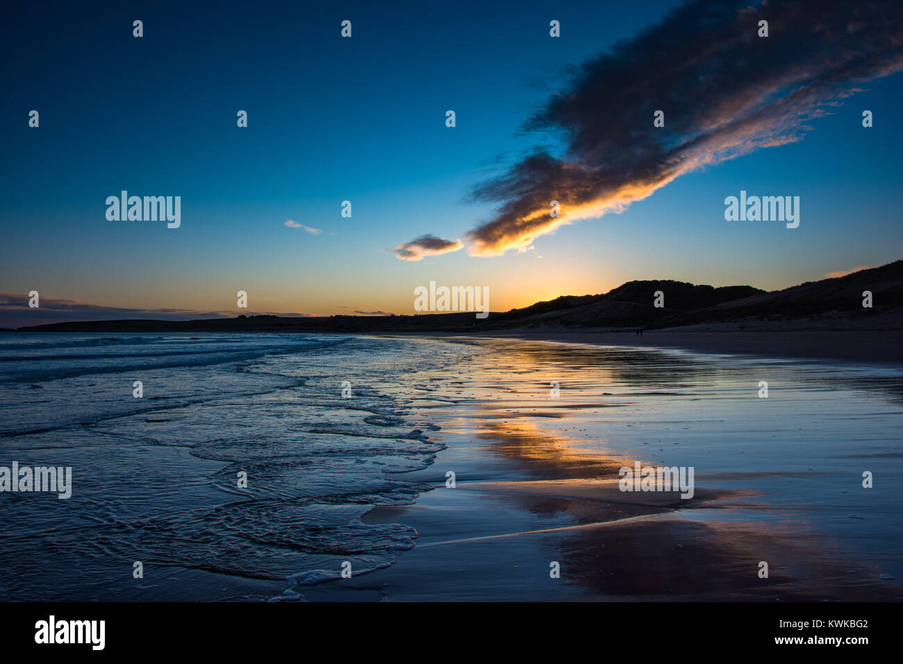 Cruden Bay, Aberdeenshire, Schottland. Farben eines Sonnenuntergangs sind in den Gewässern eines Ebbe am ersten Tag von 2018 wider Stockfoto
