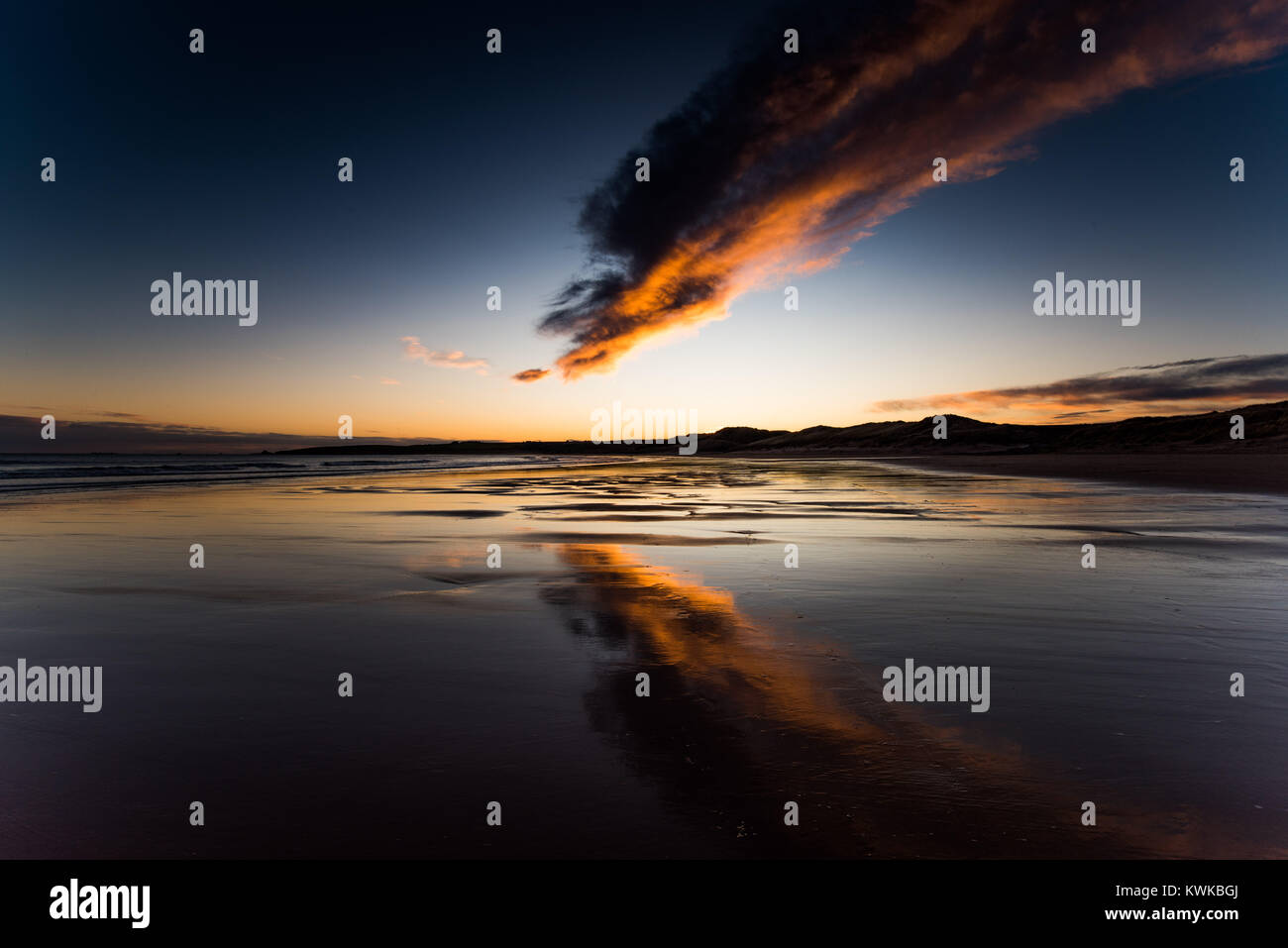 Cruden Bay, Aberdeenshire, Schottland. Farben eines Sonnenuntergangs sind in den Gewässern eines Ebbe am ersten Tag von 2018 wider Stockfoto