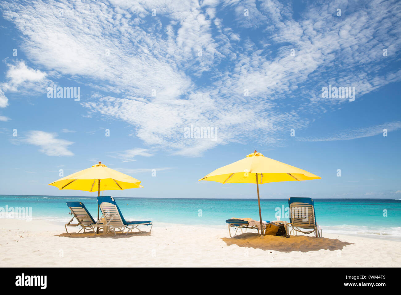 Malerischer Blick auf die Sonnenschirme und Liegestühle am Strand gegen bewölkter Himmel während der sonnigen Tag Stockfoto