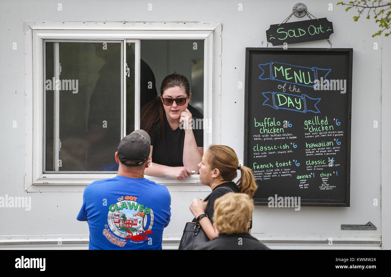 Davenport, Iowa, USA. 25 Apr, 2017. Abigail Graham, Miteigentümer der Noshery, spricht mit ein Paar nach dem Verkauf von Lebensmitteln innerhalb der ersten 90 Minuten, in nur 100 Gäste durch Wetter in Davenport am Dienstag, den 25. April 2017 des rauhen dienen. Die Viererkabel-städte unabhängige Essen Lkw-Verbindung hat seine Saison mit vier Lkws am Bechtel Park entlang nach Osten 2. und Iowa Straßen. Der Verband bezieht 12 Anbieter und hofft, ein vielfältiges kulinarisches Erlebnis in der Gemeinschaft zur Verfügung zu stellen und die Förderung von Engagement für die Gemeinschaft und der Entwicklung der Unternehmer. (Bild: © Stockfoto