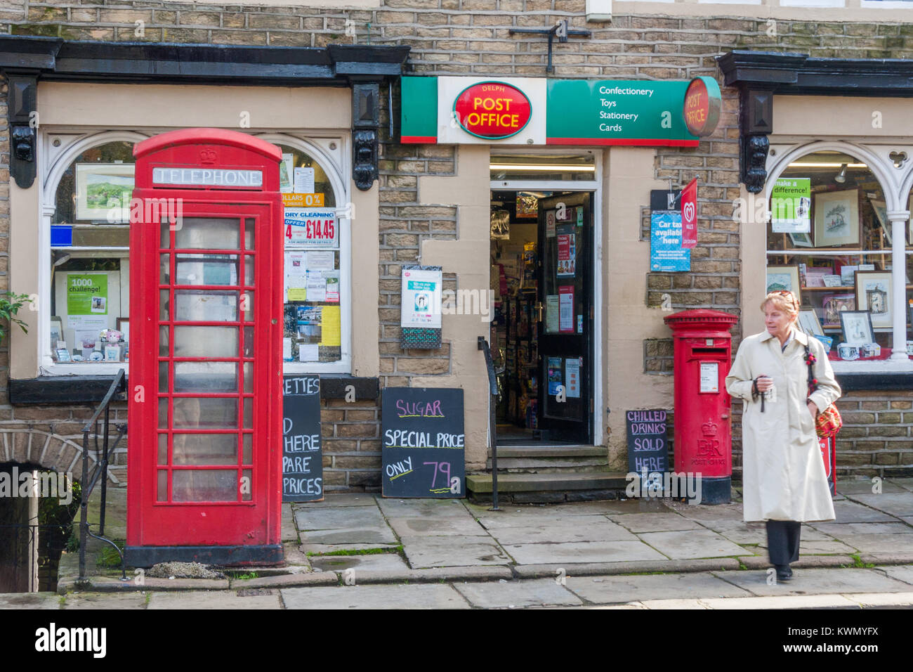 Frau wartet, die Straße nach Verlassen der Delph Post, Oldham, England, Vereinigtes Königreich, Stockfoto