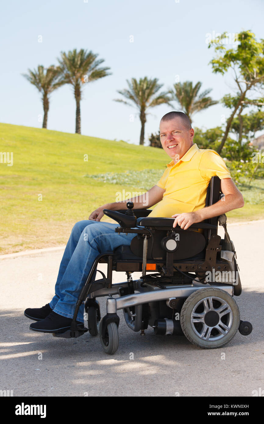 Behinderte Mann sitzt im Rollstuhl im Park Stockfoto