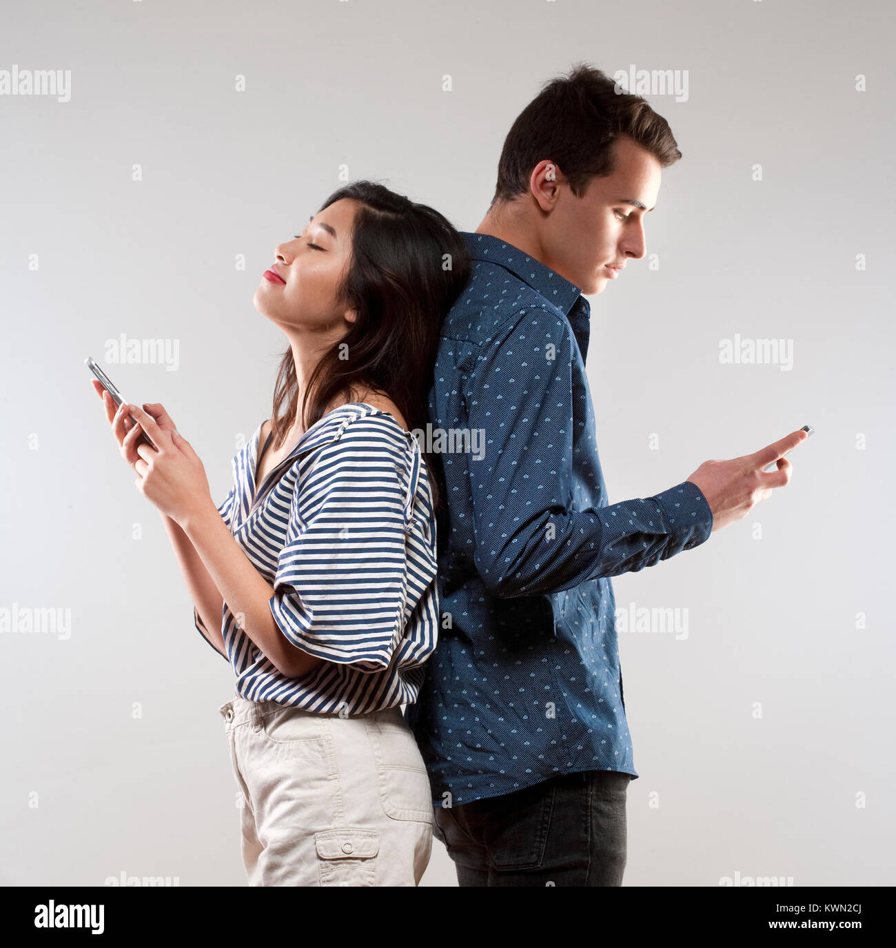 Porträt eines jungen Paares mit Smartphones Texting. Stockfoto