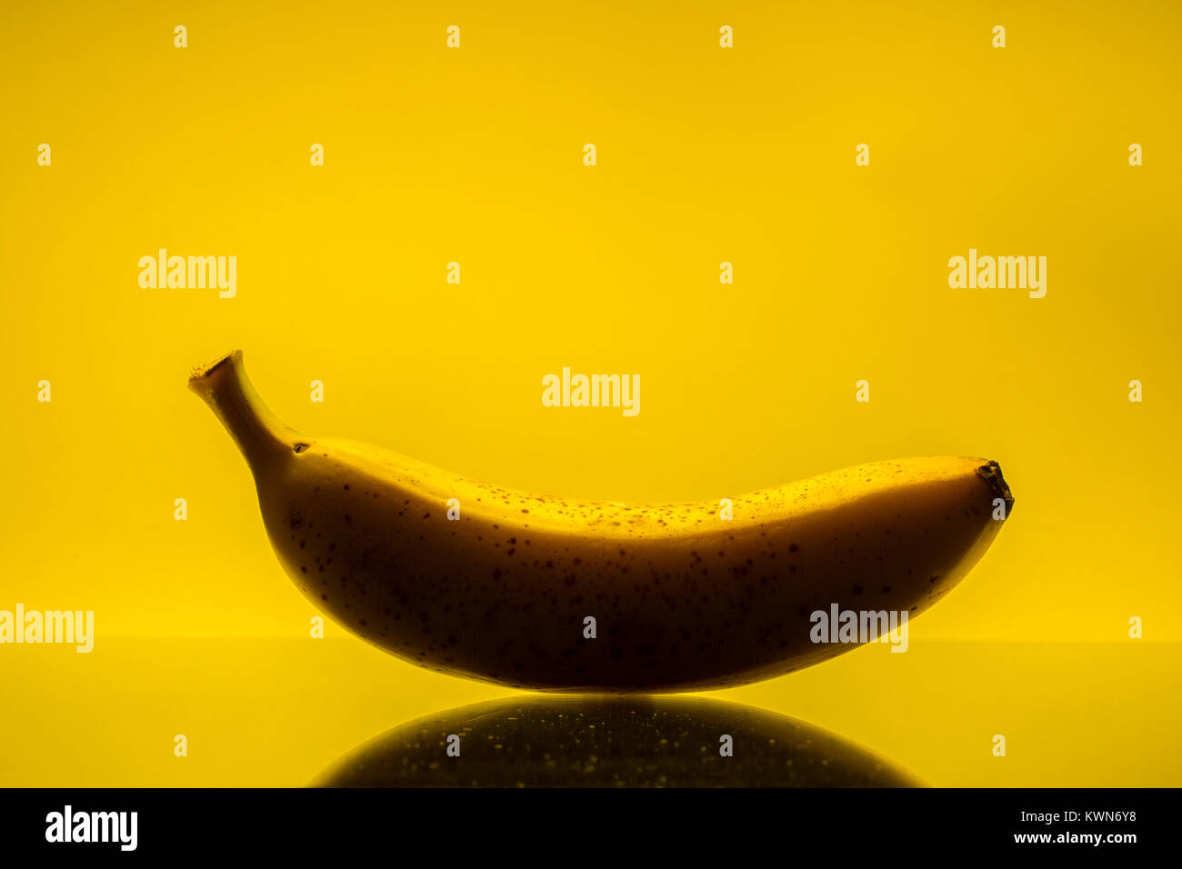 Banane gegen gelben Hintergrund Stockfoto