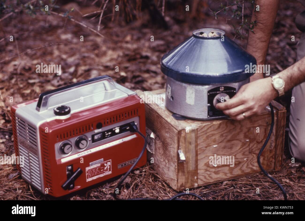 Dieses Feld ist ein Techniker die Arbeit mit dem Field Zentrifugation Ausrüstung und einem tragbaren Generator in diesem 1974 arbovirus Studie, 1974. Eine Zentrifuge ist ein Laborgerät, dass trennt Mischproben in homogene Komponente Schichten durch Drehen Sie bei hoher Geschwindigkeit. Mit freundlicher CDC. Stockfoto