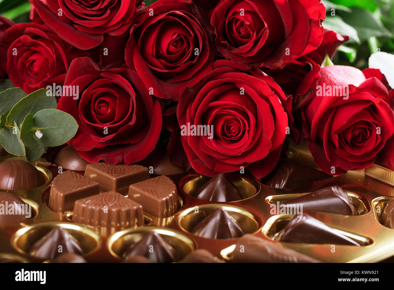 Leuchtend rote Rosen auf eine Schachtel Schokolade zum Valentinstag, oder einen Tag zu sagen Ich liebe Dich. Stockfoto