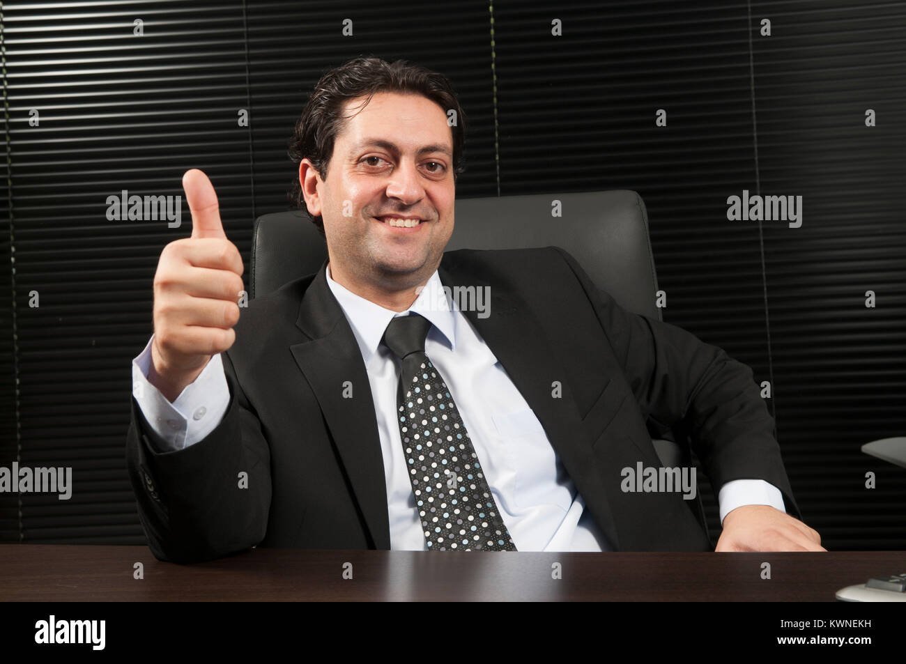 Happy business Mann mit einem Daumen nach oben Geste im Büro Stockfoto