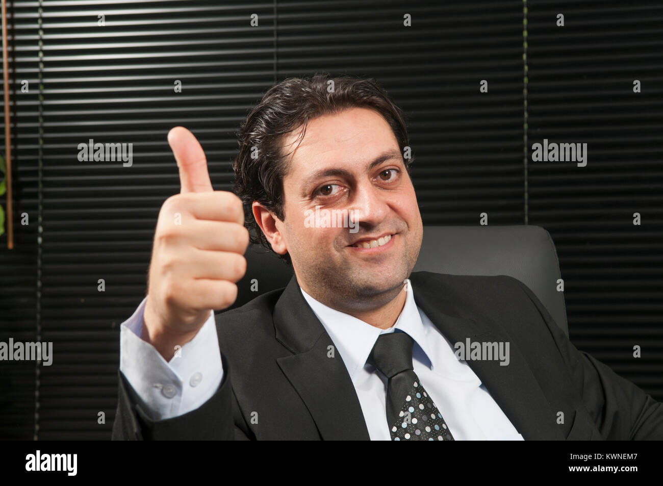 Happy business Mann mit einem Daumen nach oben Geste im Büro Stockfoto