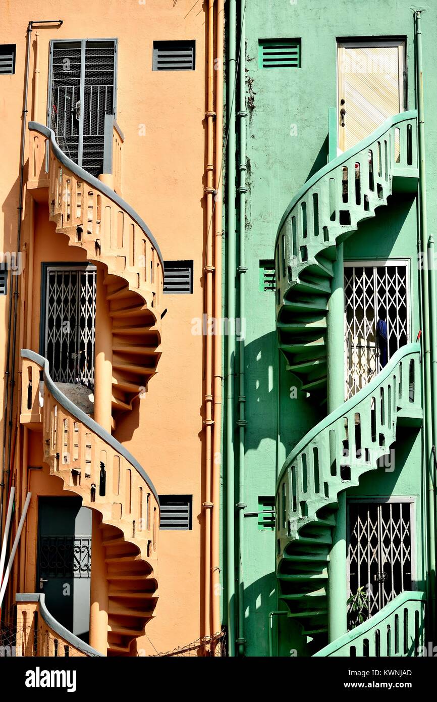 Ein paar bunte alte steinerne Wendeltreppen an der Außenseite von Terrassierten shop Häuser in historischen Little India, Singapur Stockfoto