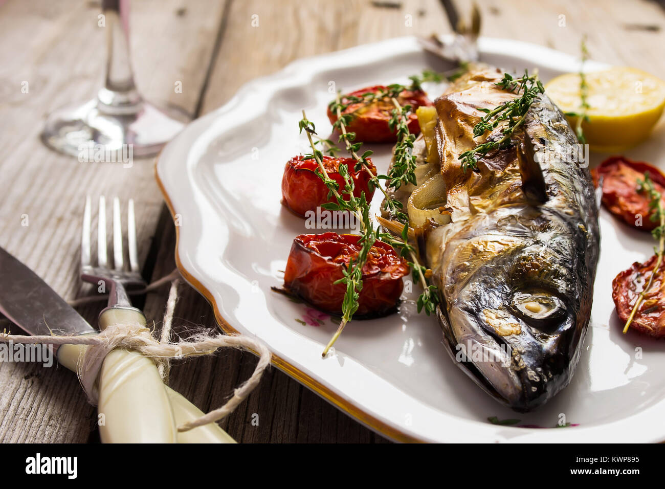 Gebackene Makrele mit Tomate und Zitrone in einem Jahrgang. Stockfoto