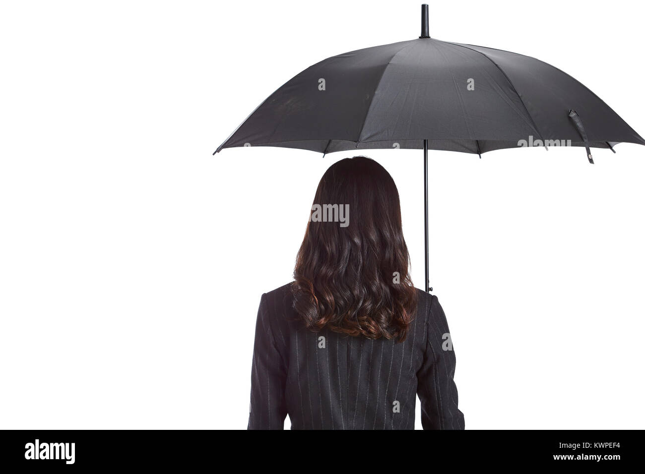 Studio Aufnahme einer jungen asiatischen Business Frau mit einem schwarzen Regenschirm, Rückansicht, auf weißem Hintergrund. Stockfoto