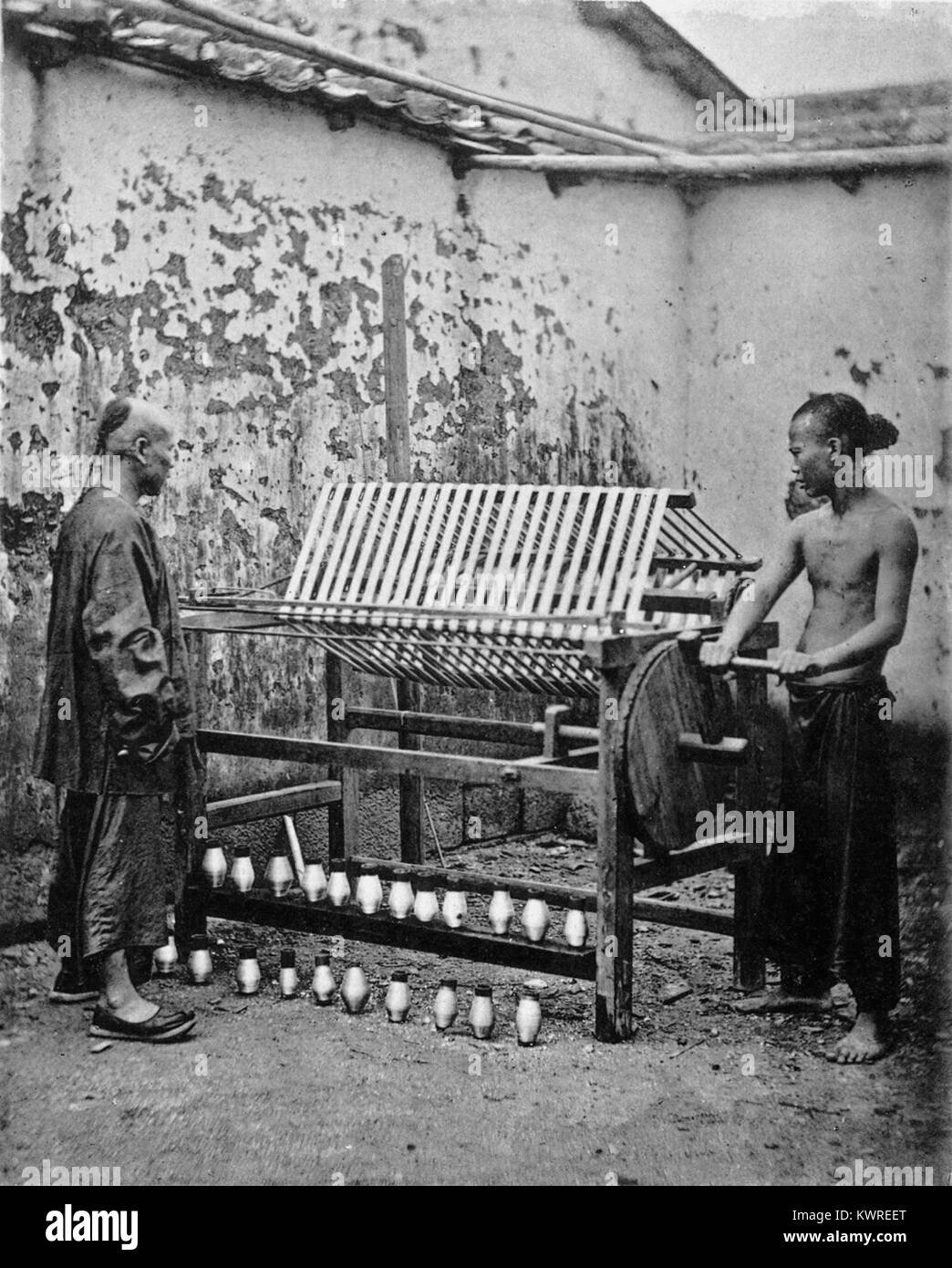 Das Bild zeigt den traditionellen Prozess der Seidenspule, bei dem Seidenfasern sorgfältig aus Seidenraupen extrahiert werden, einem wesentlichen Bestandteil der Seidenproduktion in der Textilindustrie. Stockfoto